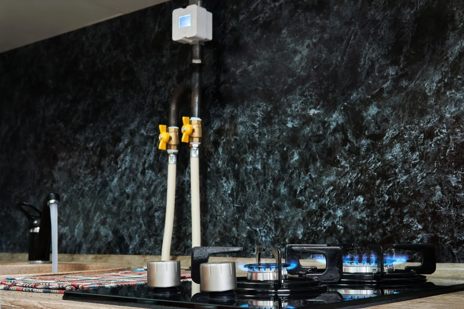 A gas stove with a hose attached to it